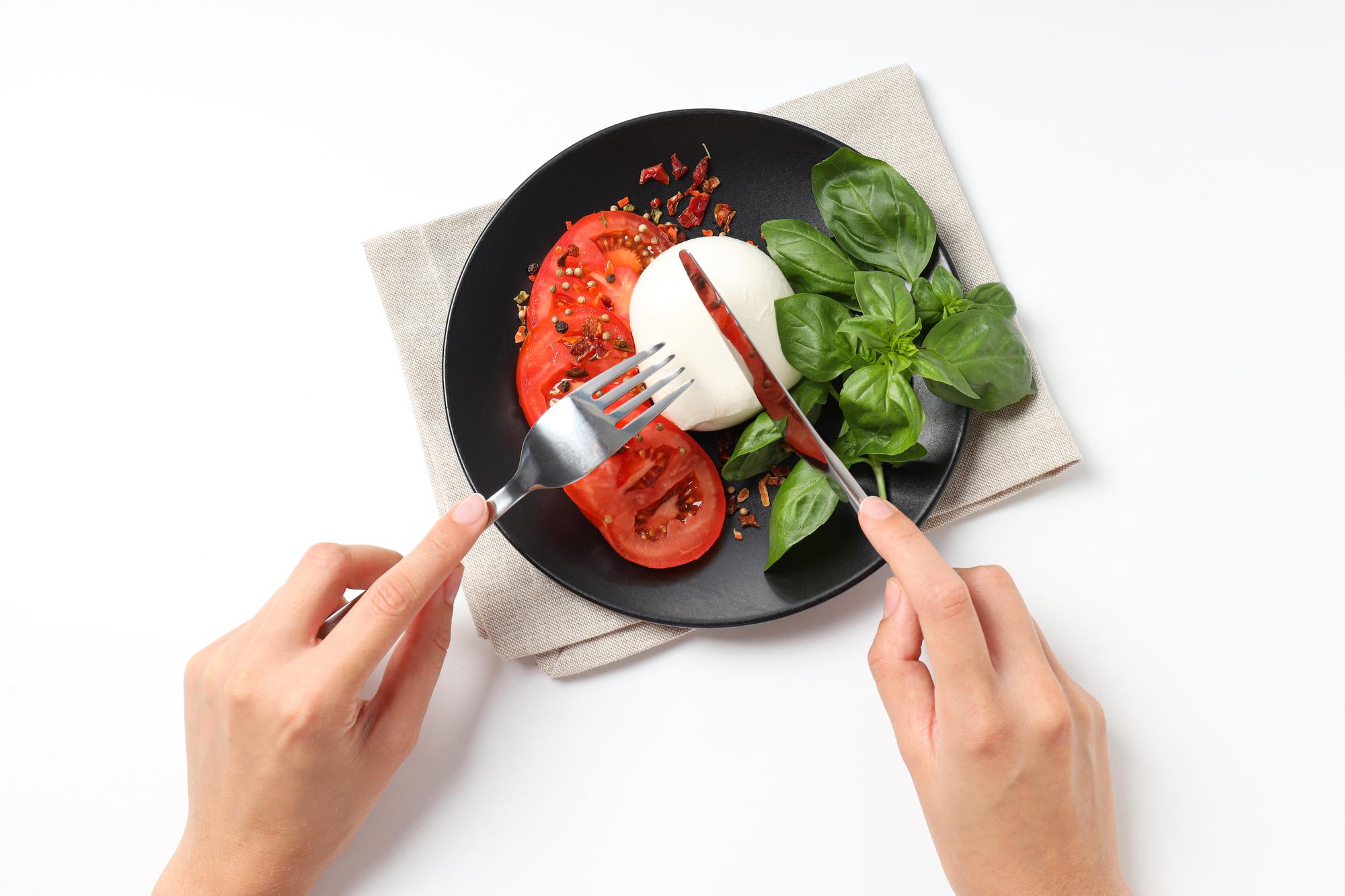 Hands arranging garnish on a plate